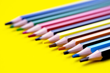 Fototapeta premium Colored pencils isolated on a yellow background. The concept of creativity development.