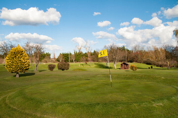 Fototapeta na wymiar A flagstick on a golf course during Summer.