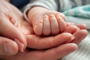 Obraz na płótnie Canvas Family Baby Hands. Closeup of baby hand into parents hands. Father and Mother Holding Newborn Kid. Family concept.