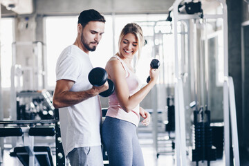 Fototapeta premium Sporty couple make weight lifting together in loft gym
