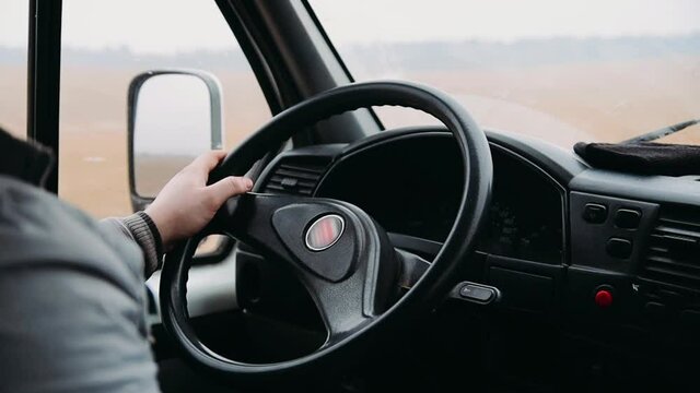 Hands Of The Truck Driver On The Steering Wheel, The Road Is Bumpy, Shaking.