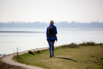 A woman Hiking on a country trail alone near the shore