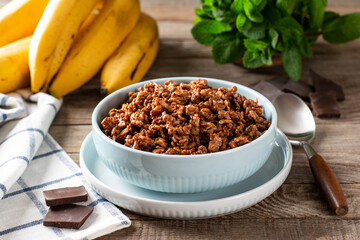 Chocolate and banana porridge on a wooden table, healthy breakfast