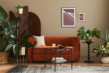 Domestic interior of living room with design sofa, mock up poster frames, a lot of plants, coffee...