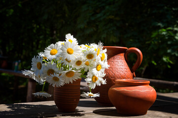Bouquet of daisies and clay jugs