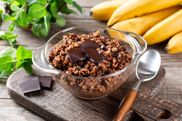 Chocolate oatmeal or oat porridge with chocolate on top served in small bowl. Selective Focus