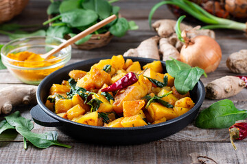 Aloo Palak sabzi - Potato cooked with spinach with added spices. A healthy Indian main course recipe. Served in a frying pan