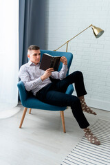 man sitting on a chair with book