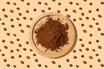 Coffee ground beans on a beige background, hard trend light