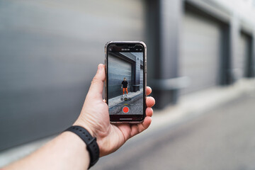 Chico manejando smartphone vestido con ropa negra