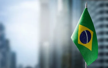 Foto op Plexiglas Brazilië Een kleine vlag van Brazilië op de achtergrond van een onscherpe achtergrond
