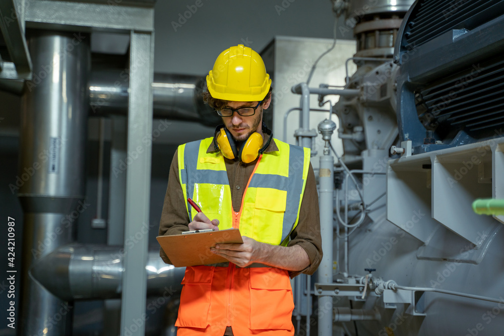 Poster Technician engineer checking controls system for security functions in service room at factory,Heating,Ventilation,Air Conditioning.