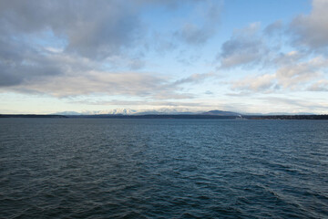 Fototapeta premium The Olympic mountains of Washington State viewed from across the water covered in snow.