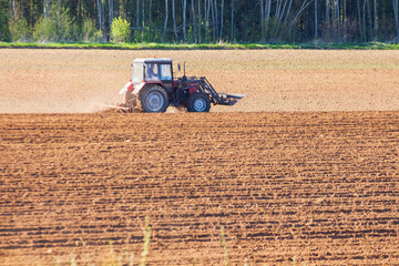 tractor plows the field on a sunny spring day