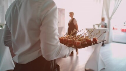 male waiter serving catering on banquet and holding meat snack on plate