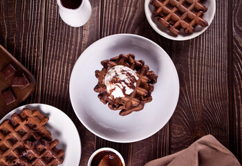 Homemade chocolate waffles with ice cream decorated chocolate syrup.