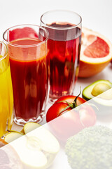 freshly squeezed fruit juice in glass glasses with a composition of fruit on a light background