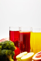 freshly squeezed fruit juice in glass glasses with a composition of fruit on a light background