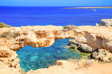 Fototapeta na wymiar Seascape, sea waves break on the rocks, Lovers' Bridge, Cyprus, Cape Kavo Greko