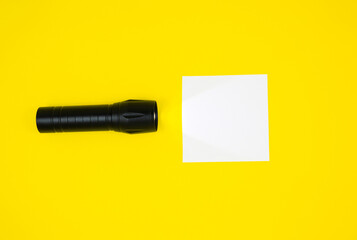 Blank white To Do List Sticker with black flashlight. Searching information on the Internet..Close up of reminder note paper on the yellow background. Copy space. Minimalism, original and creative.