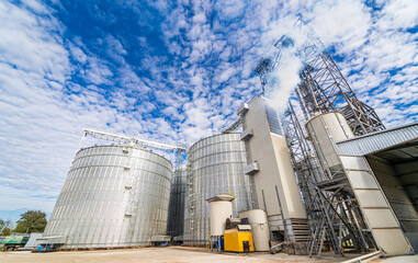 Obraz premium Tanks and agricultural silos of grain elevator storage. Loading facility building exterior. View from below.