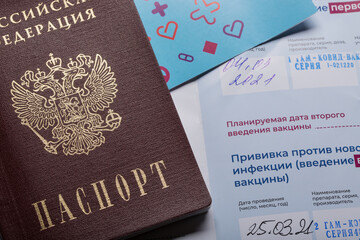 Extreme close up of Russian passport laying down on COVID-19 vaccination certificate.