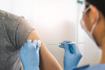 People getting a vaccination to prevent pandemic concept. Woman in medical face mask  receiving a dose of immunization coronavirus vaccine from a nurse at the medical center hospital