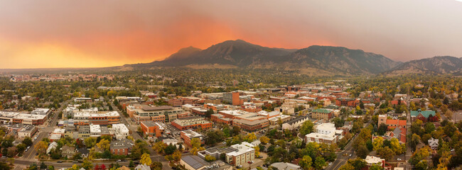 aerial sunset panorama through smoke and clouds of Boulder cityscape and mountain landscape