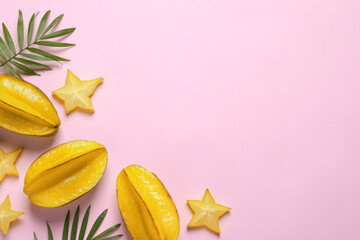 Delicious carambola fruits on pink background, flat lay. Space for text