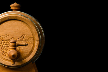 wooden barrel with a tap of Armenian wine on a black background. copyspace