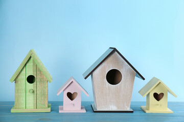 Obraz na płótnie Canvas Collection of handmade bird houses on light blue wooden table