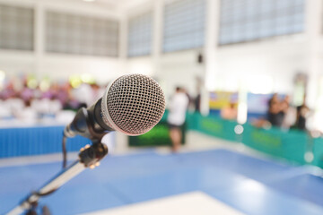 Front of Microphone with blurred many people background on the hall. Microphone on stage. activity indoor concept. seminar or meeting concept.