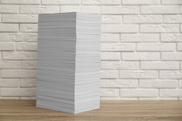 Stack of paper sheets on wooden table. Space for text