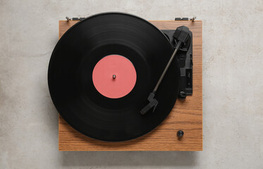 Turntable with vinyl record on light background, top view