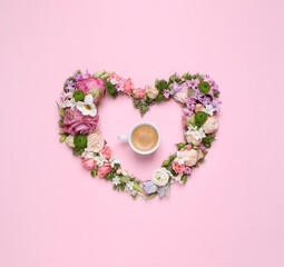 Beautiful heart made of different flowers and coffee on pink background, flat lay