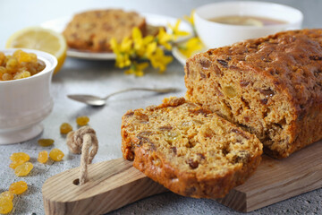 Traditional English tea raisins cake, egg-free cake and cup of lemon tea