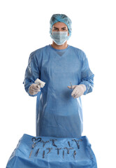Doctor holding medical clamps with pad near table of different surgical instruments on light...