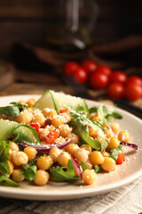 Plate with delicious fresh chickpea salad on table