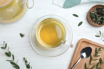 Aromatic eucalyptus tea on white wooden table, flat lay