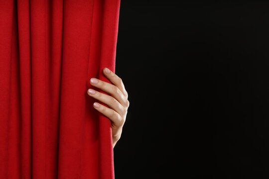 Woman Opening Red Front Curtains On Black Background, Closeup. Space For Text