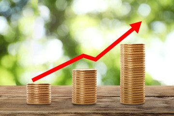 Stacked coins on wooden table against blurred background. Investment concept
