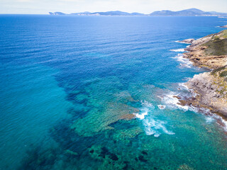 Aerial view Blue sea in Alghero shoreline with Capo Caccia on the background