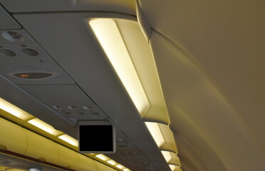 Fototapeta premium overhead cabinet for keeping passenger stuff on rooftop and exit sign in commercial plane cabin