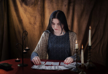young girl guessing with tarot cards on  brown  background
