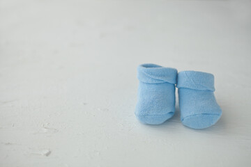 Blue baby socks on a textured rustic background with copy space. Newborn and pregnancy concept.