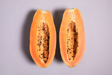 Halved papaya on pink background 