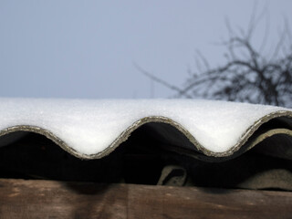 white snow on the roof covered with slate