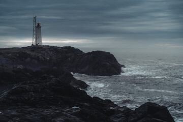 Lighthouse at Stokksnes coast in East Iceland ocean coastline. Dramatic moody landscape