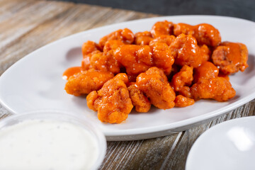 A view of a plate of boneless chicken wings.