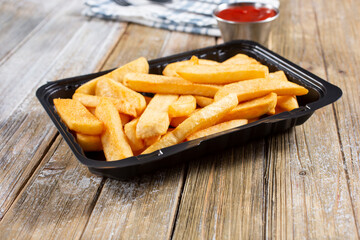 A view of a to-go container of steak fries.
